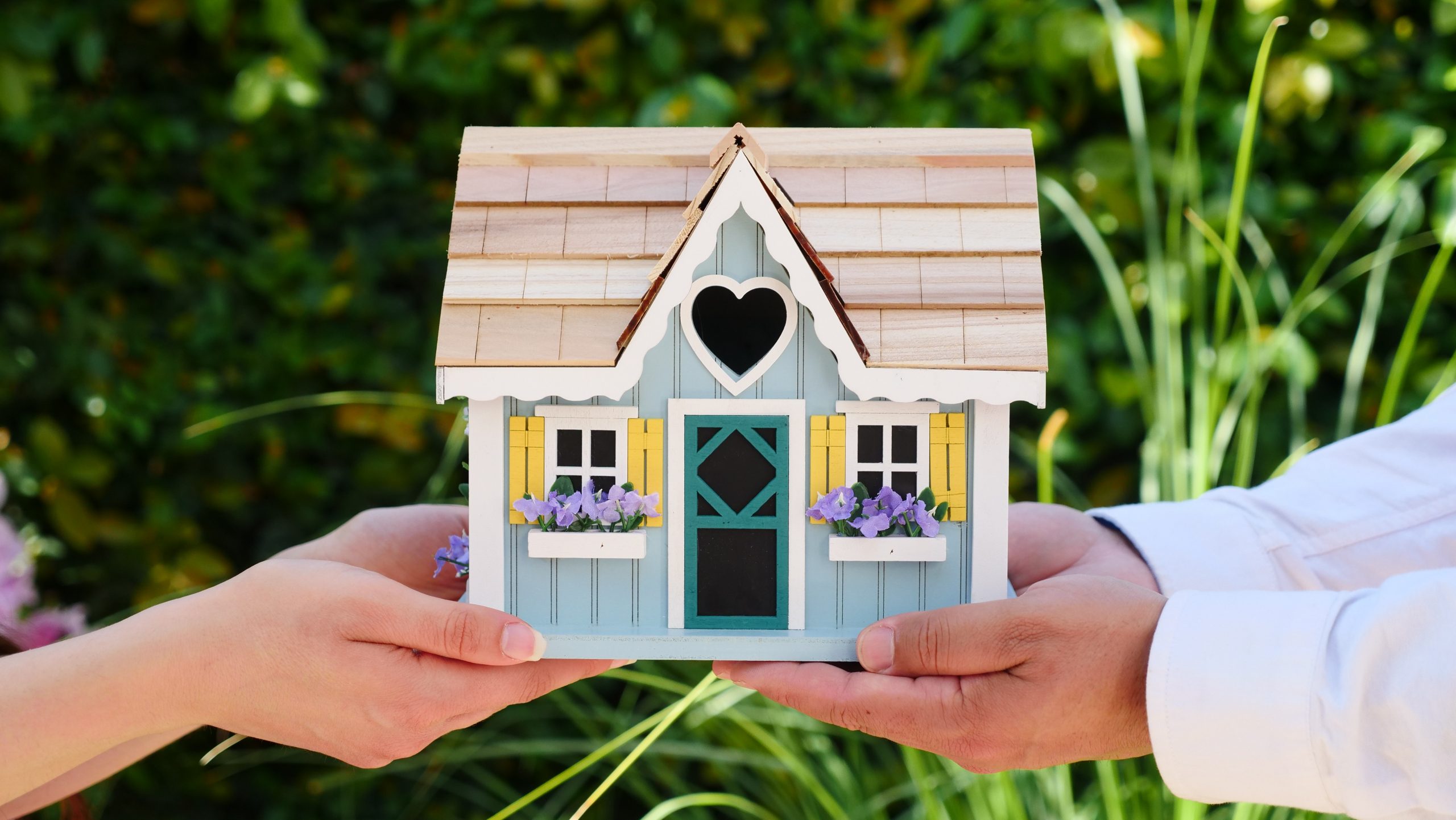 Hands holding model of a house